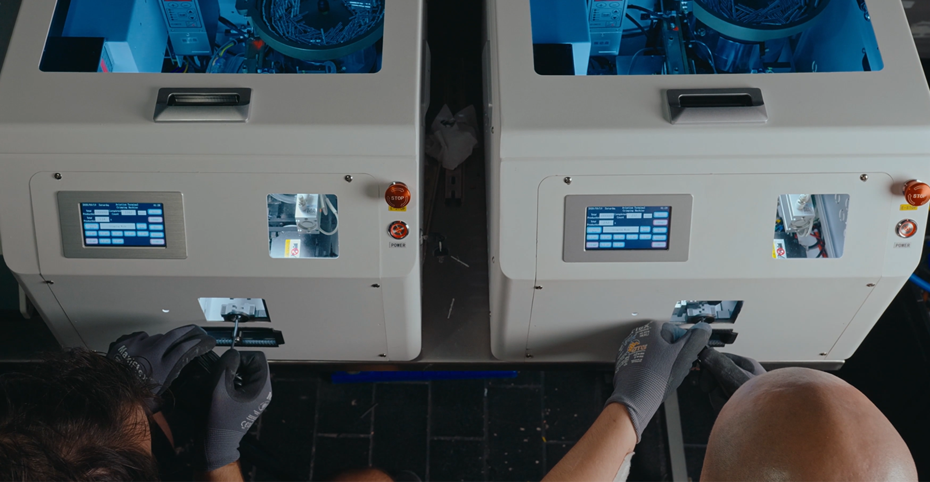 Two technicians operating automatic terminal crimping machines