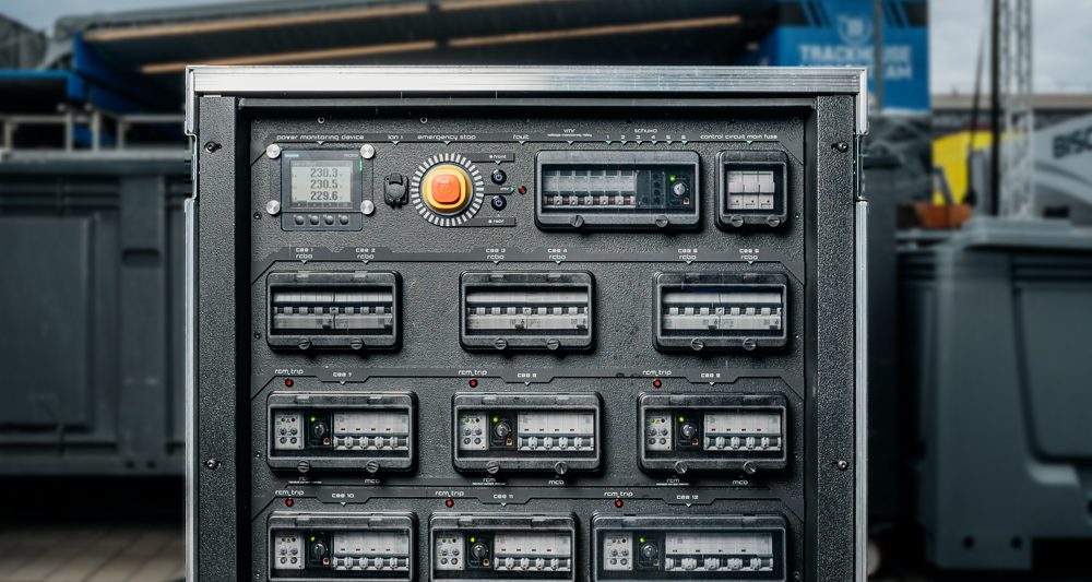 Front panel of a Tesla Tech flightcase power distribution unit with power monitoring display, emergency stop and breaker groups
